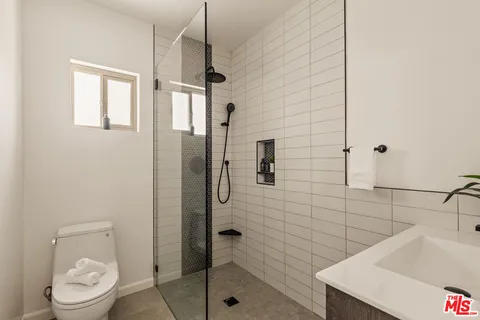 a bathroom with a sink a toilet and shower