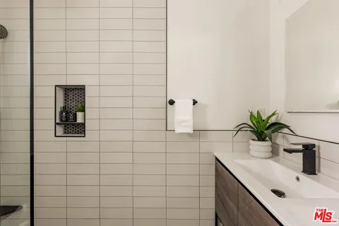 a bathroom with a sink a vanity and shower