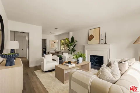 a living room with furniture a fireplace and potted plant