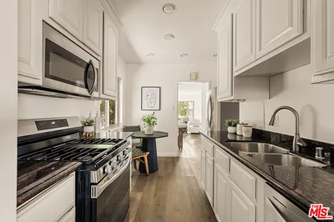 a kitchen with stainless steel appliances a stove a sink a microwave and cabinets