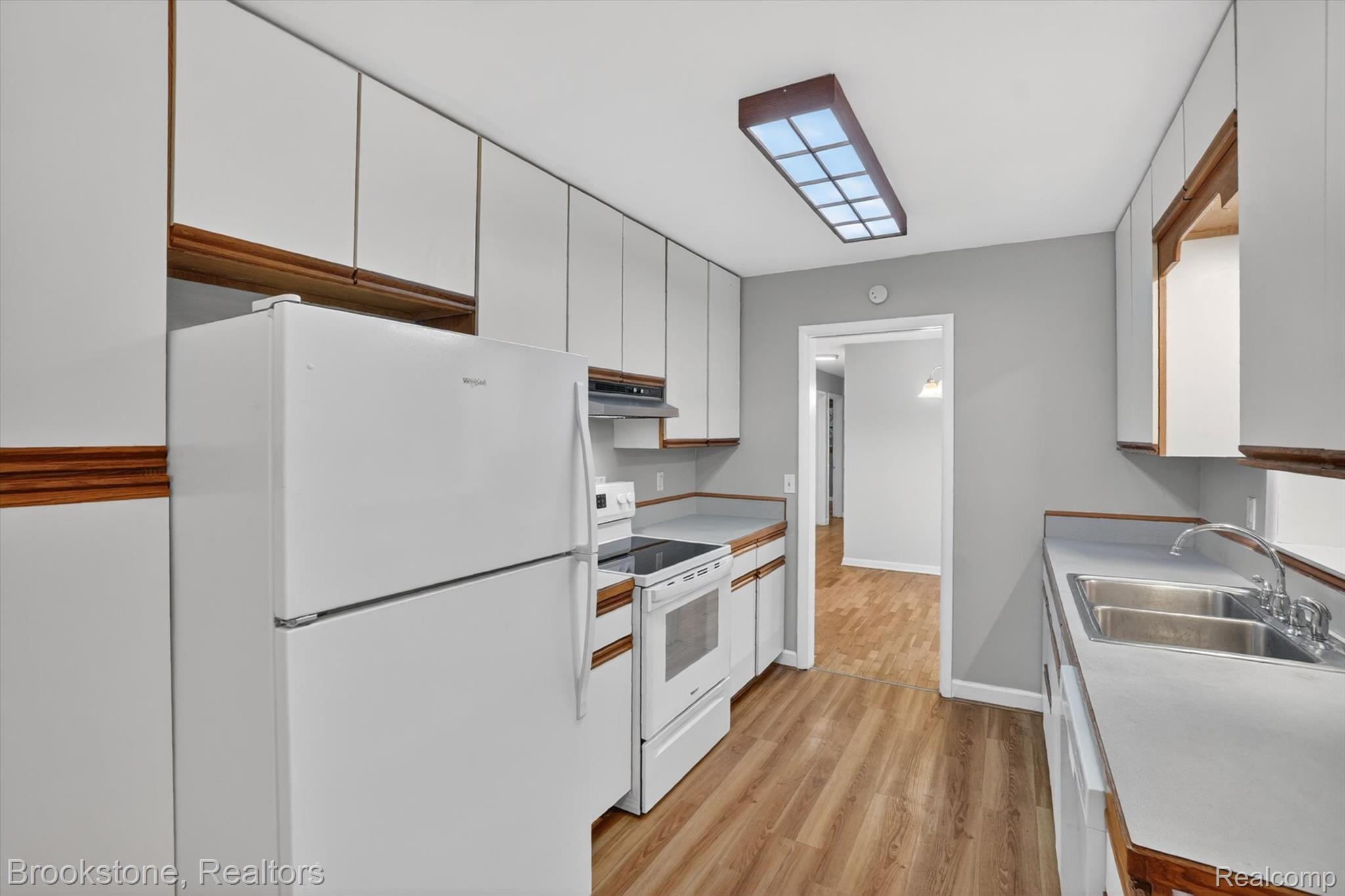 4547 Marlborough Road Okemos, MI 48864 - Photo 14 of 55 Kitchen with white appliances, light wood-style floors, light countertops, and dual tone cabinetry