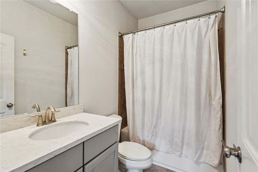 4846 Ralin Court Southwest Atlanta, GA 30331 - Photo 19 of 38 a bathroom with a sink a toilet and shower curtain