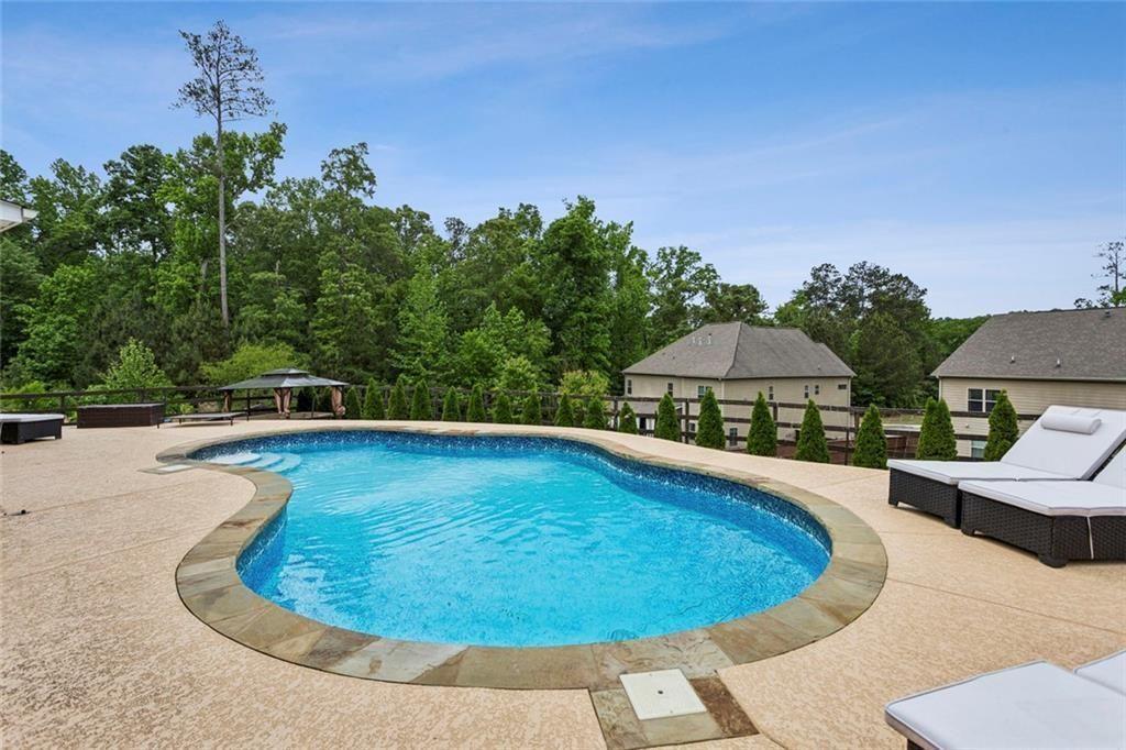 4846 Ralin Court Southwest Atlanta, GA 30331 - Photo 27 of 38 a view of a swimming pool with lawn chairs under an umbrella