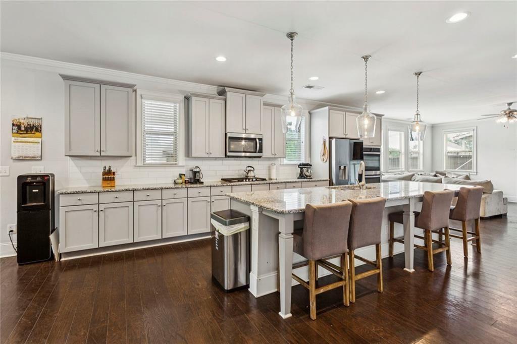 4846 Ralin Court Southwest Atlanta, GA 30331 - Photo 5 of 38 a kitchen with stainless steel appliances granite countertop a table chairs stove microwave and cabinets