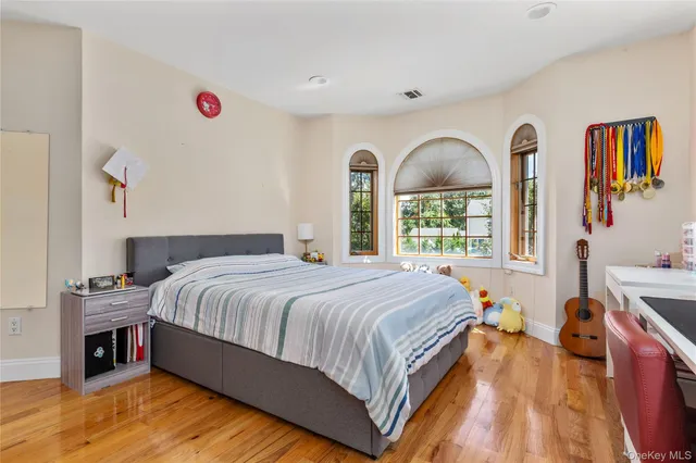 a spacious bedroom with a bed and a dresser