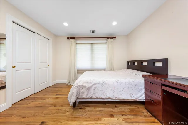 a bedroom with a bed and a wooden floor