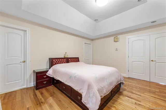 a large bedroom with a bed and wooden floor
