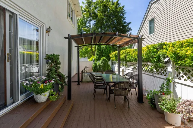 a backyard of a house with potted plants and a large tree