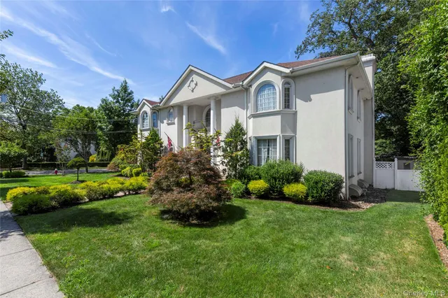 a front view of a house with a garden and plants