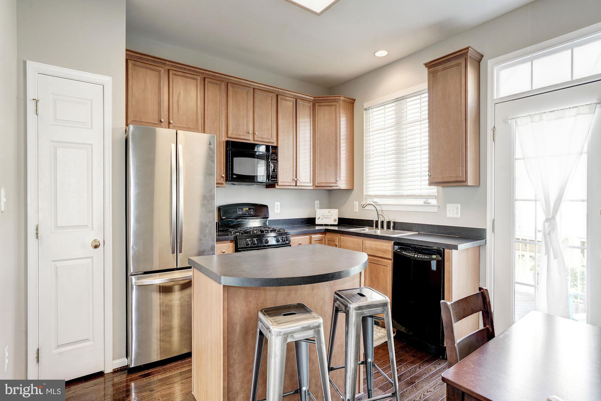 25013 Riding Center Drive Chantilly, VA 20152 - Photo 13 of 28 a kitchen with stainless steel appliances granite countertop a stove a refrigerator a sink a oven with white cabinets and wooden floor