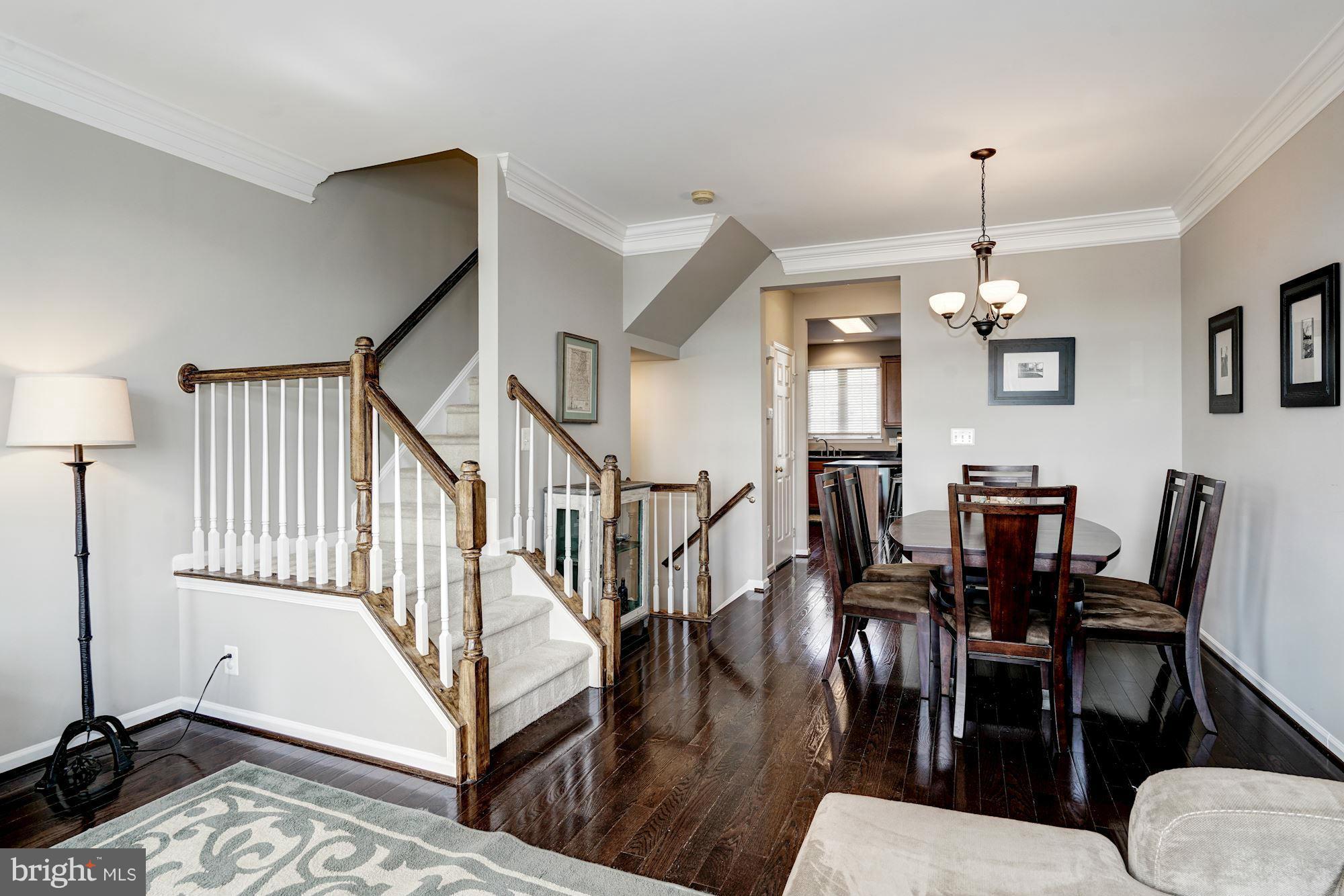 25013 Riding Center Drive Chantilly, VA 20152 - Photo 10 of 28 a view of a dining room and livingroom with furniture wooden floor a rug a chandelier and a rug