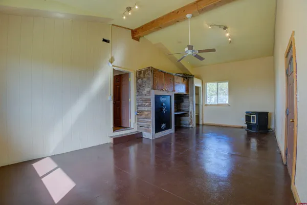 an empty room with wooden floor fireplace and windows