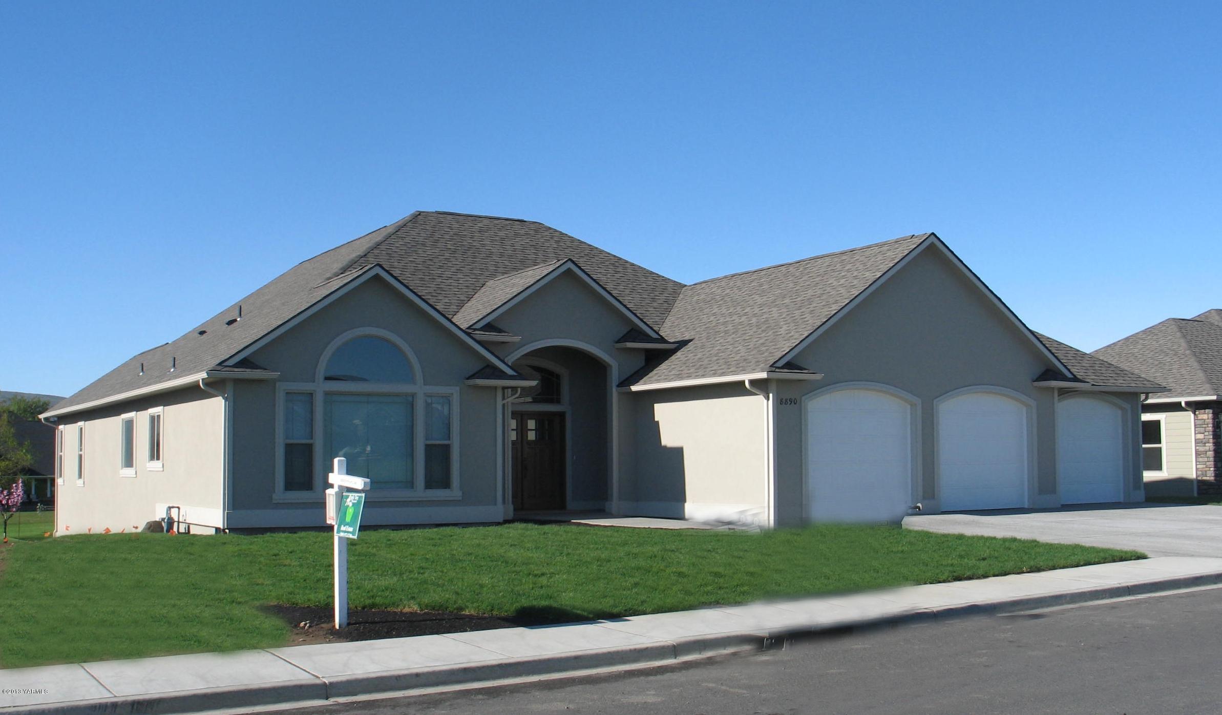 8890 Coolidge Road, Unit 3 Yakima, WA 98903 - Photo 1 of 8 a front view of a house with a yard and garage