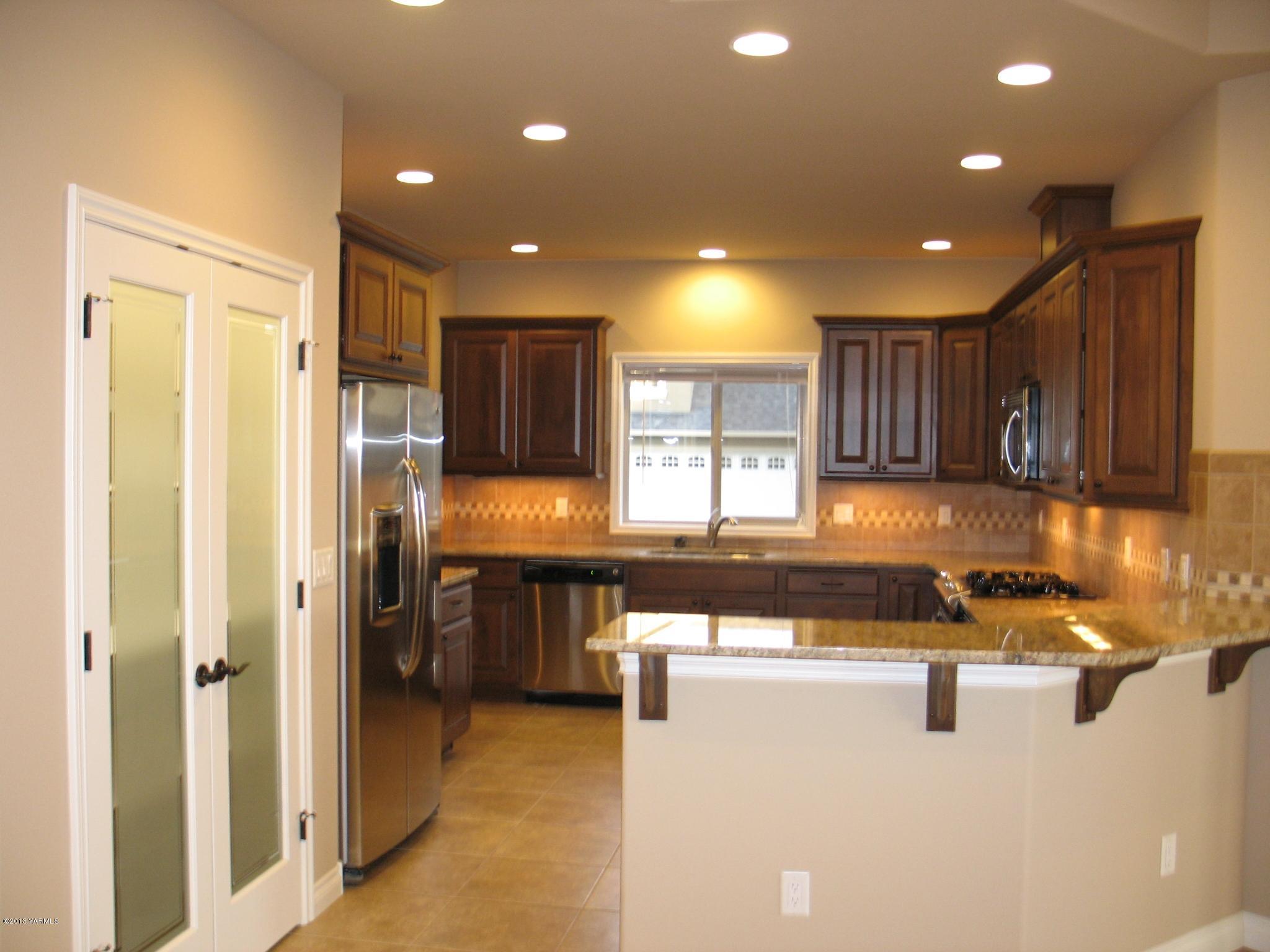 8890 Coolidge Road, Unit 3 Yakima, WA 98903 - Photo 2 of 8 a kitchen with stainless steel appliances granite countertop a refrigerator a sink and a microwave