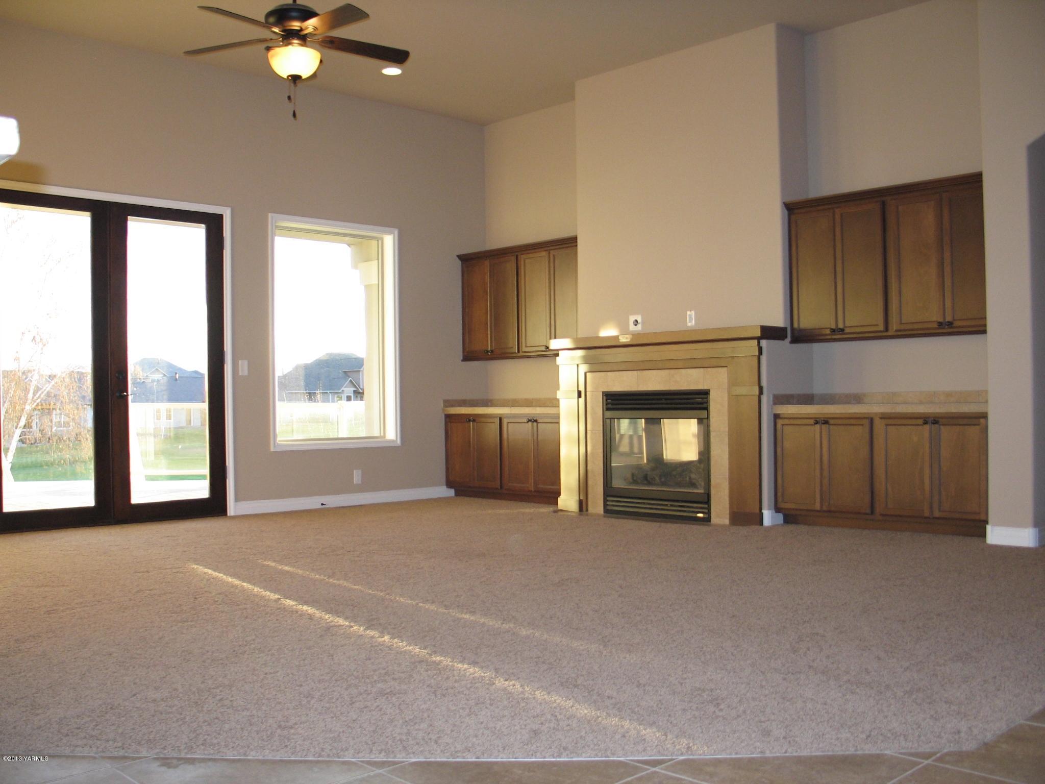 8890 Coolidge Road, Unit 3 Yakima, WA 98903 - Photo 3 of 8 a view of an empty room with a fireplace and a window