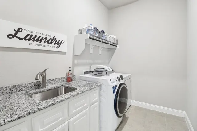 a utility room with sink dryer and washer