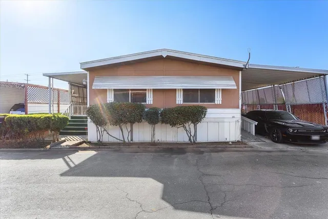 a view of a house with a patio and a yard