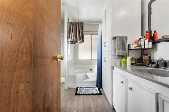 a bathroom with a granite countertop shower a sink and a mirror