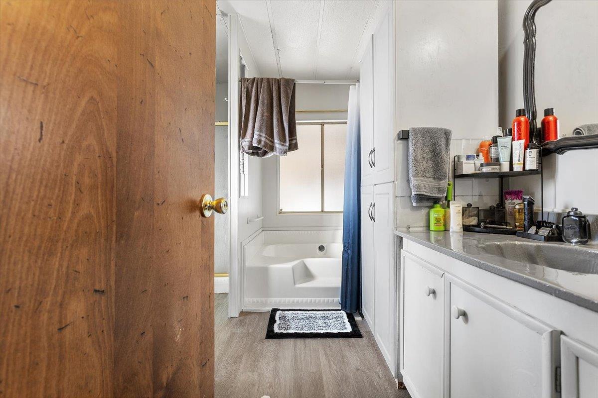 4837 Faith Home Road, Unit 177 Ceres, CA 95307 - Photo 16 of 31 a bathroom with a granite countertop shower a sink and a mirror