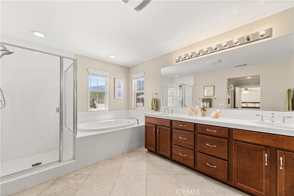 4976 Golden Ridge Place Rancho Cucamonga, CA 91739 - Photo 36 of 56 Primary bath with his and her sinks, stand up shower, soaking tub, private commode, and mountain views