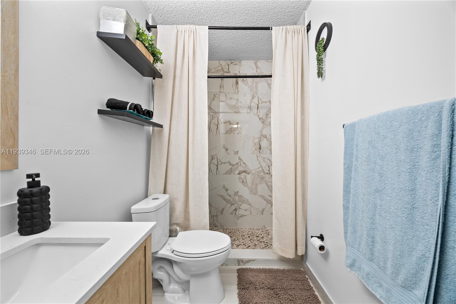 600 Northwest 99th Street, Unit A Miami, FL 33150 - Photo 13 of 23 a bathroom with a sink a toilet and shower