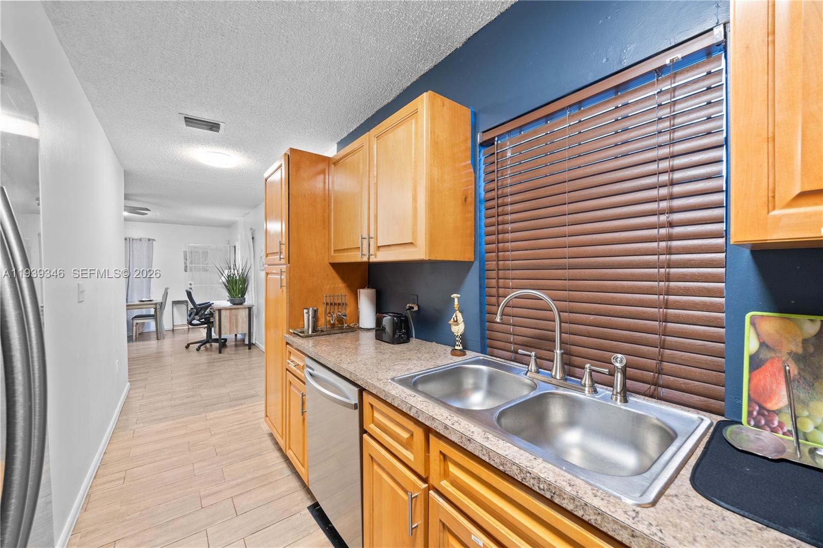 600 Northwest 99th Street, Unit A Miami, FL 33150 - Photo 8 of 23 a kitchen with sink refrigerator and cabinets