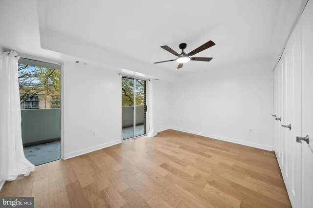 a view of an empty room with window and wooden floor