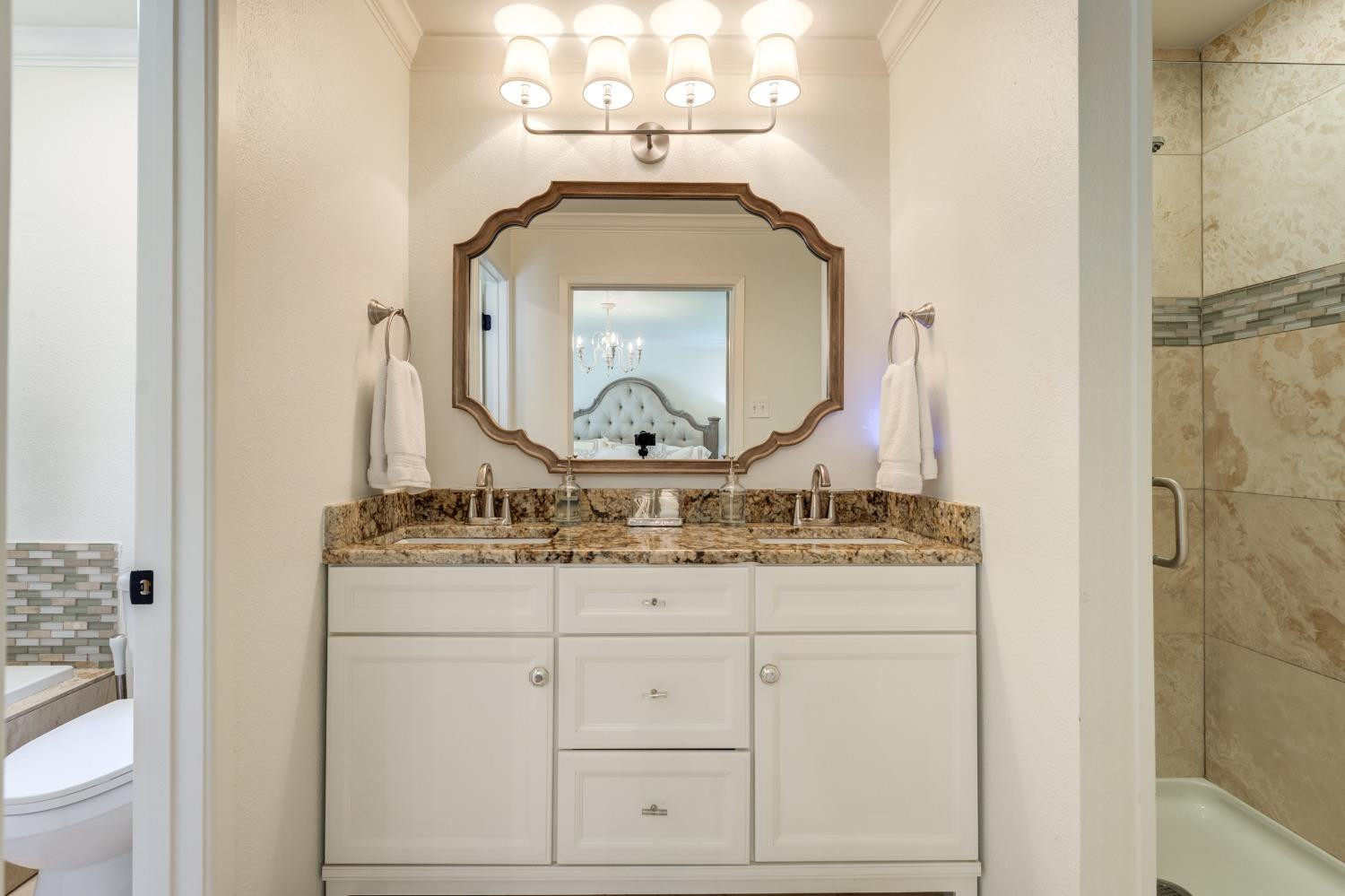 4520 8th Street Lubbock, TX 79416 - Photo 35 of 49 a bathroom with a granite countertop sink vanity and mirror