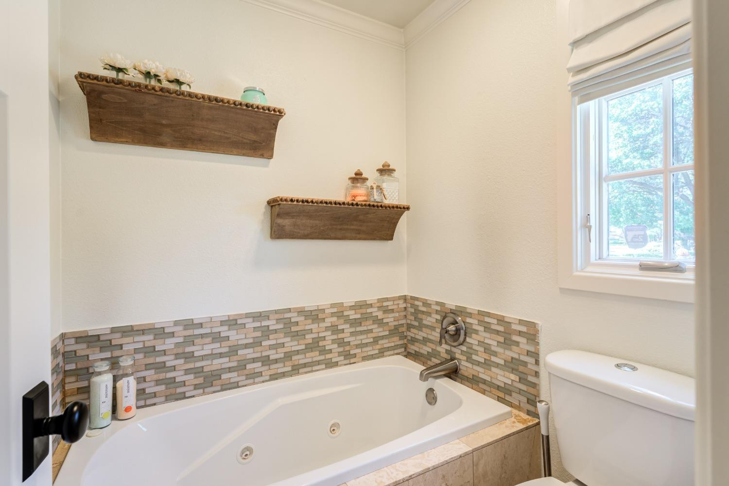 4520 8th Street Lubbock, TX 79416 - Photo 36 of 49 a bathroom with a bathtub and a window