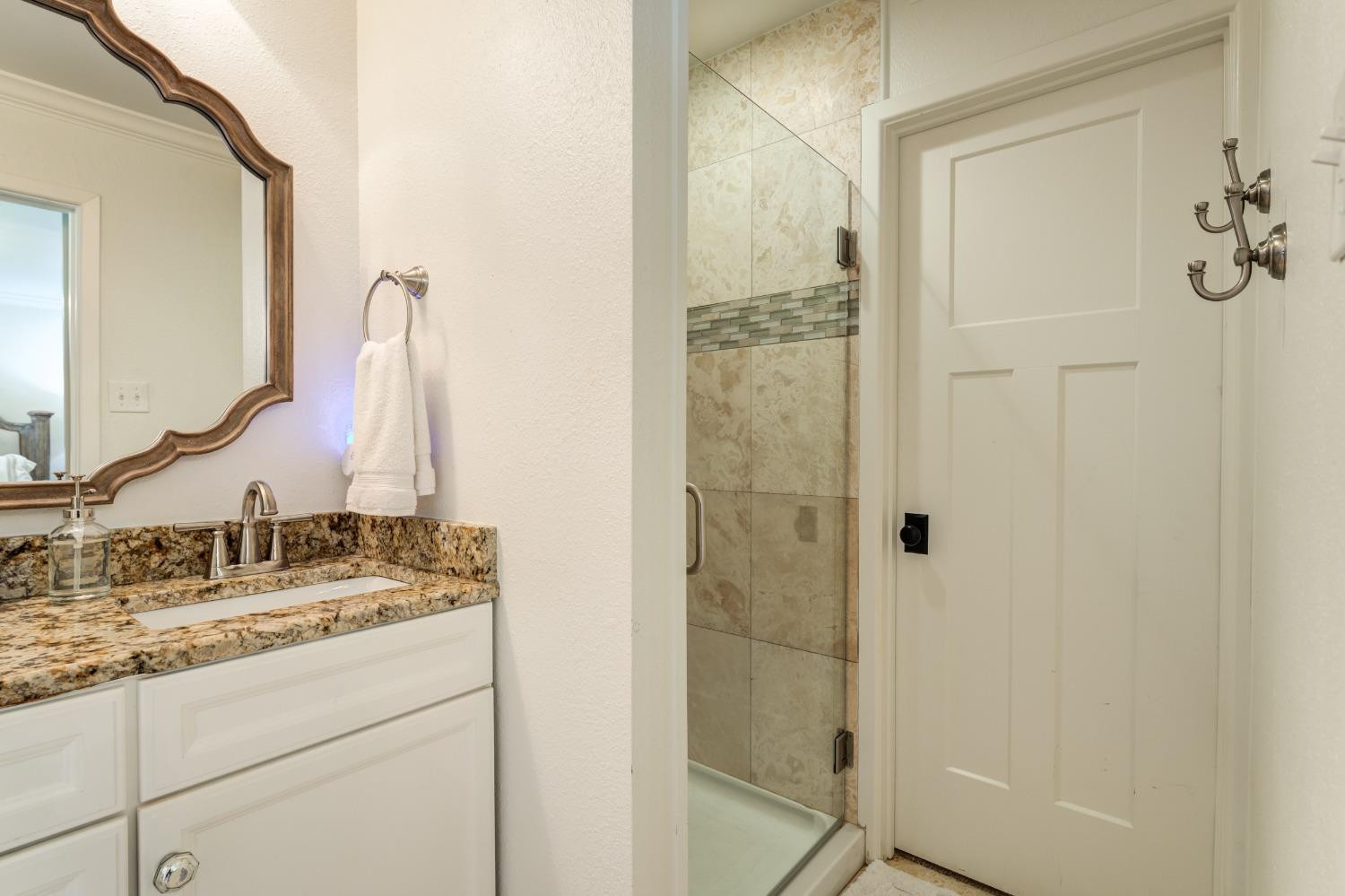 4520 8th Street Lubbock, TX 79416 - Photo 37 of 49 a bathroom with a granite countertop sink and a mirror