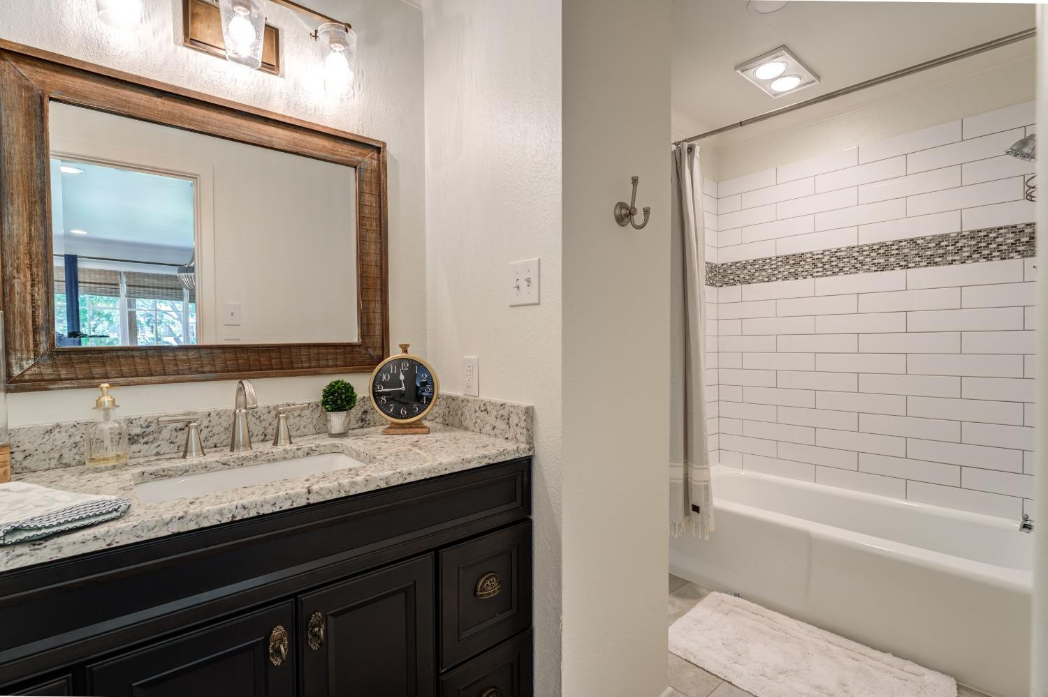 4520 8th Street Lubbock, TX 79416 - Photo 40 of 49 a bathroom with a granite countertop sink a toilet and bathtub