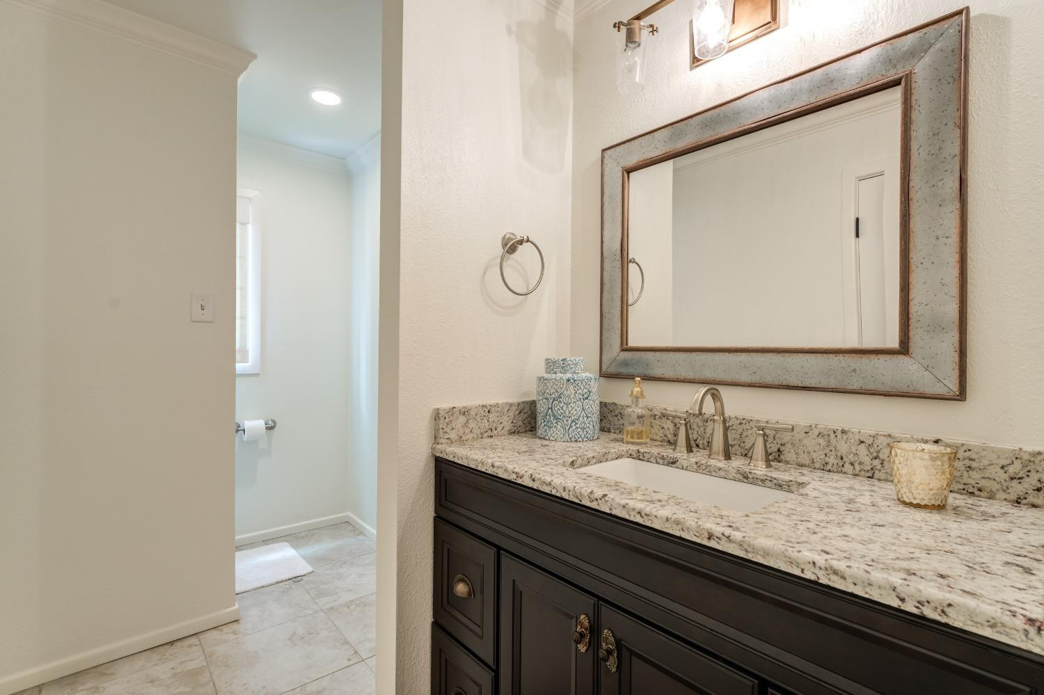 4520 8th Street Lubbock, TX 79416 - Photo 43 of 49 a bathroom with a granite countertop sink vanity and a mirror