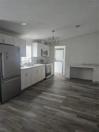 a kitchen with stainless steel appliances granite countertop a refrigerator and a stove top oven