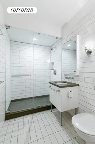 a bathroom with a granite countertop sink a toilet a mirror and shower