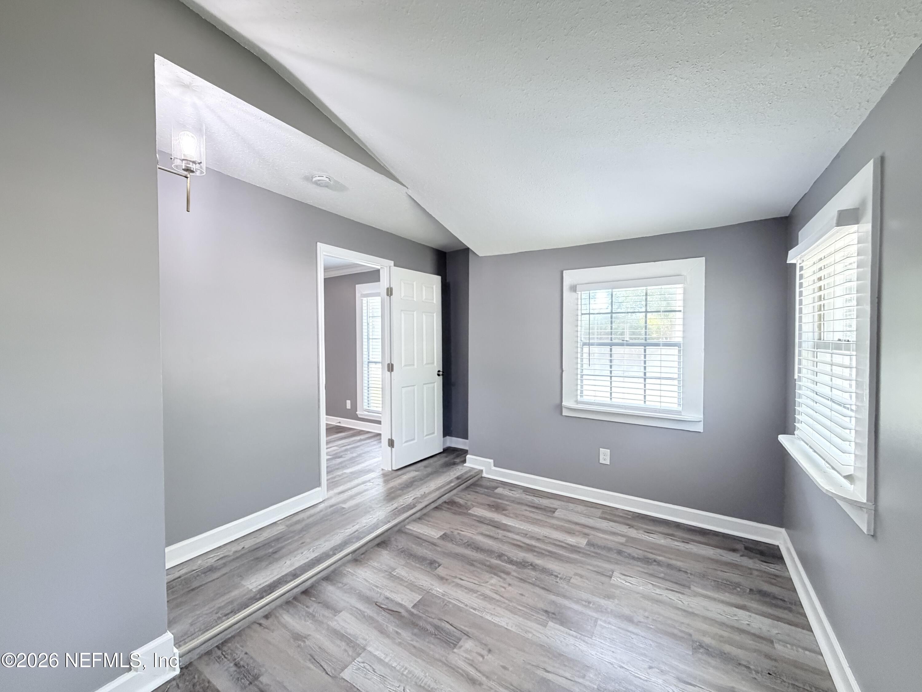 5336 Cruz Road Jacksonville, FL 32207 - Photo 10 of 29 a view of an empty room with wooden floor and a window
