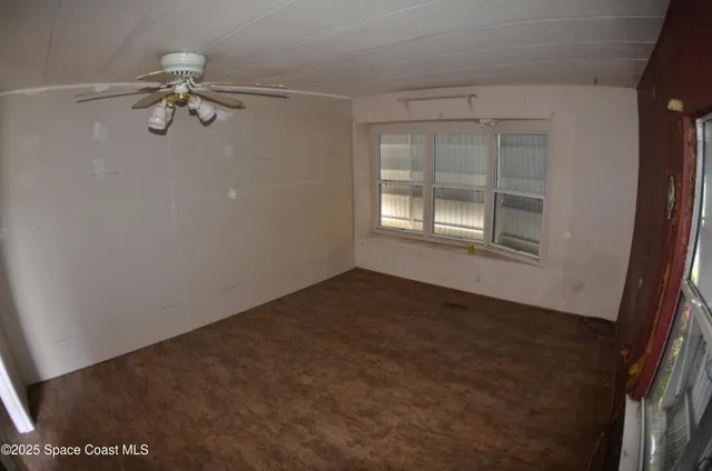 a view of a livingroom with a ceiling fan and window