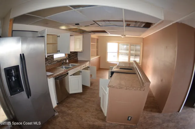 a kitchen with sink refrigerator and window