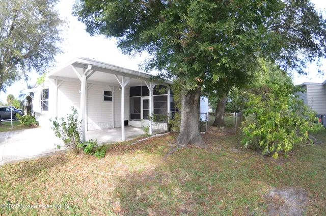 a view of a house with a yard and potted plants