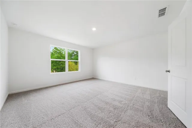 an empty room with windows and fireplace