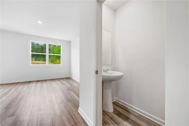 a view of a room with wooden floor a ceiling fan and a window