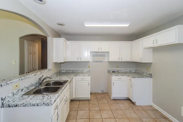 a kitchen with a stove a sink a refrigerator and cabinets