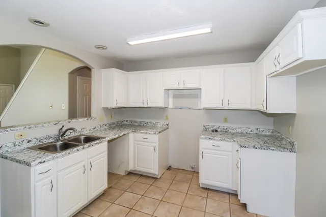 a kitchen with white cabinets appliances and sink