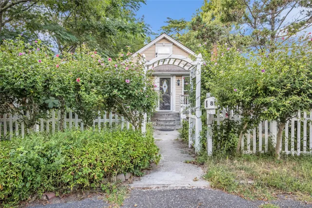 a view of a street with potted plants and large trees