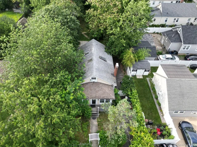 a front view of a house with a yard and lake view