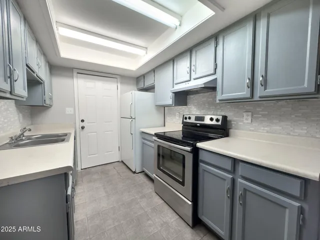 a kitchen with stainless steel appliances granite countertop white cabinets stove a sink and dishwasher
