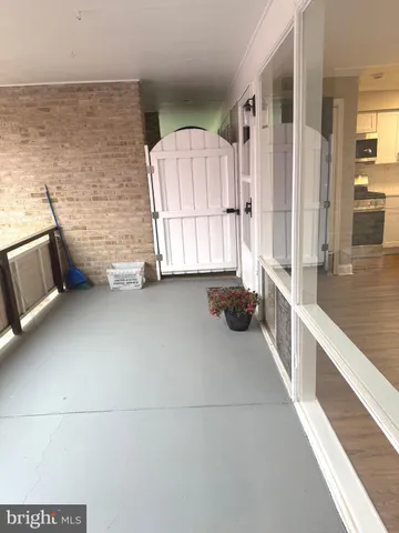 an empty room with wooden floor and outdoor seating