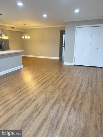 a view of a room with wooden floor and white walls