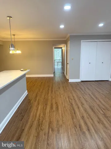 a large kitchen with stainless steel appliances a large counter top a stove and a wooden floors