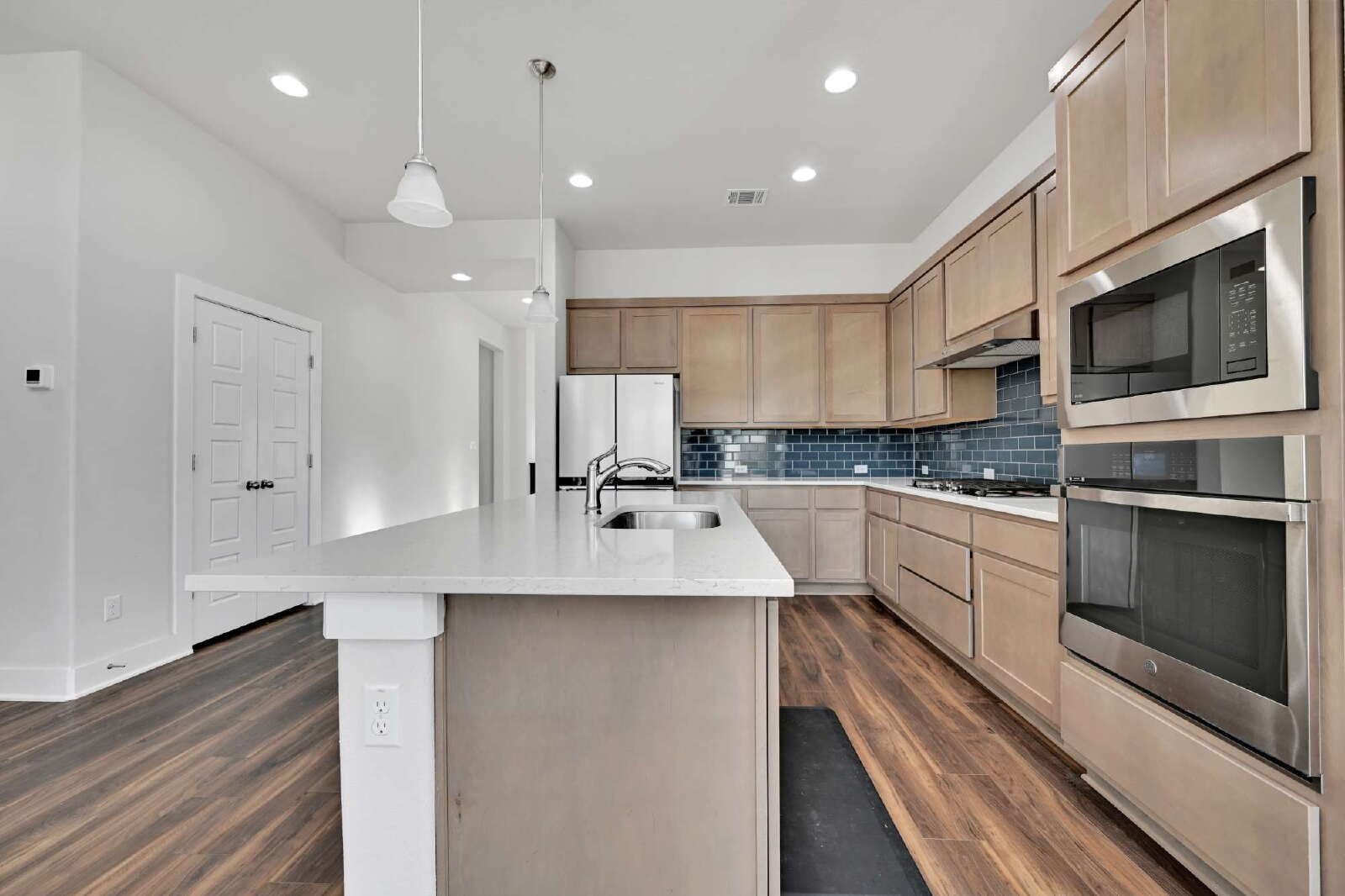 4420 Kings Cross Road Pflugerville, TX 78660 - Photo 9 of 25 Gleaming stone countertops and warm wood floors define this modern culinary workspace.