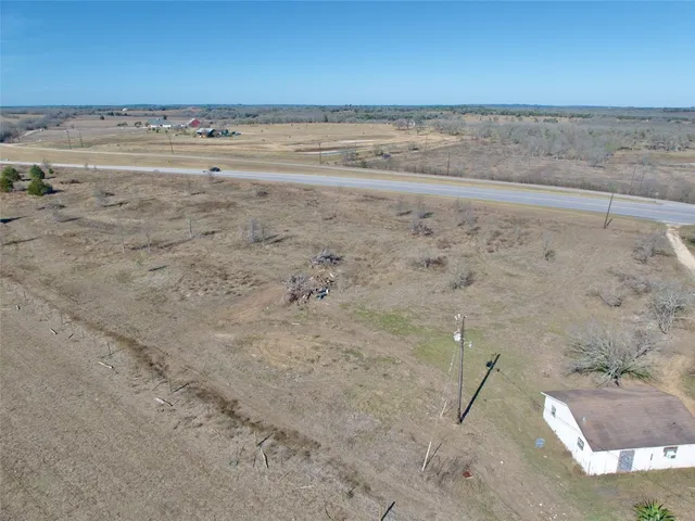 a view of a dry yard with wooden floor and fence